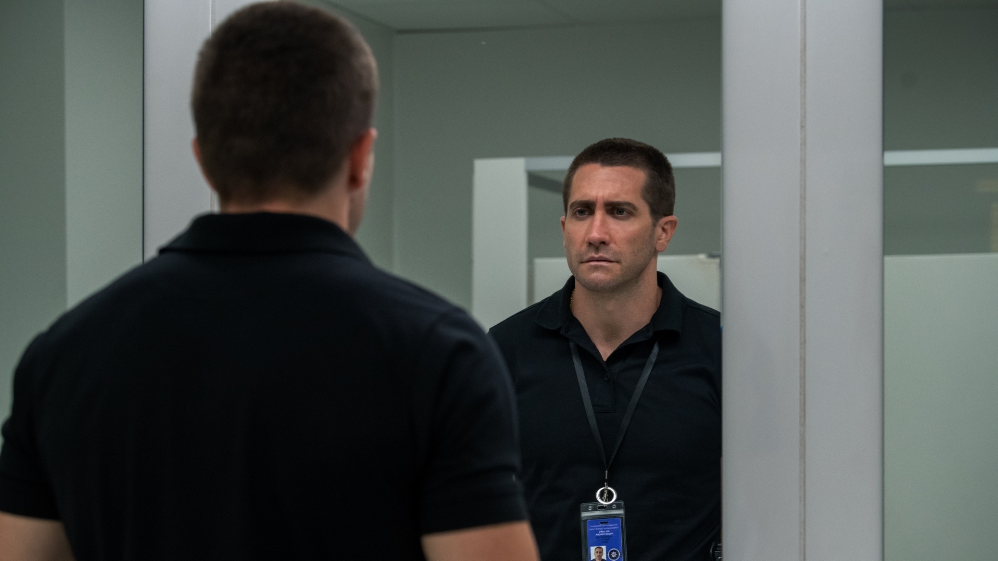 A man stares at his own reflection in the mirror.