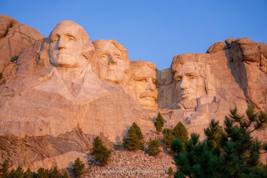 Mount Rushmore bathed in pink and orange hues at sunrise in the Black Hills, South Dakota