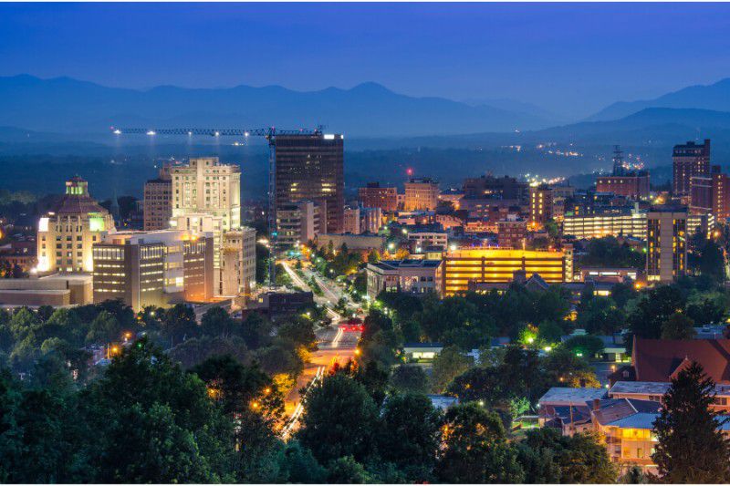 Nighttime view of Asheville, North Carolina with mountains in the background